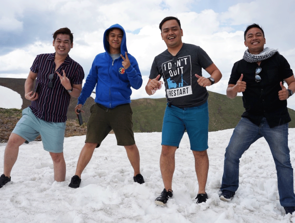 Group of men standing on snow, smiling