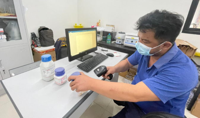 Man labeling chemicals in lab